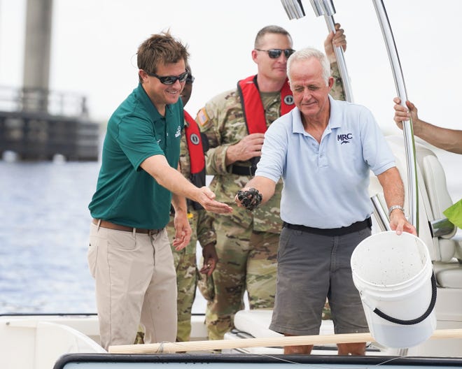 Indian Riverkeeper Jim Moir (right) shows the black sediment on the floor of the St. Lucie River while taking a tour with Gen. Jason Kelly, of the U.S. Army Corps of Engineers South Atlantic Division, Col. James Booth, of the Jacksonville District and Stuart Mayor Merritt Matheson on Thursday, June 9, 2022, in Martin County.  The floor of this area of the river was once an expansive oyster reef, but years of Lake Okeechobee discharges changed the floor of the river from sand to black muck. "The main reason for this is to get the Army Corps out on the water," said Matheson. "Showing someone physically what they are trying to fix, what they're striving to keep, improve or showing them the problems that have occurred has a real impact."