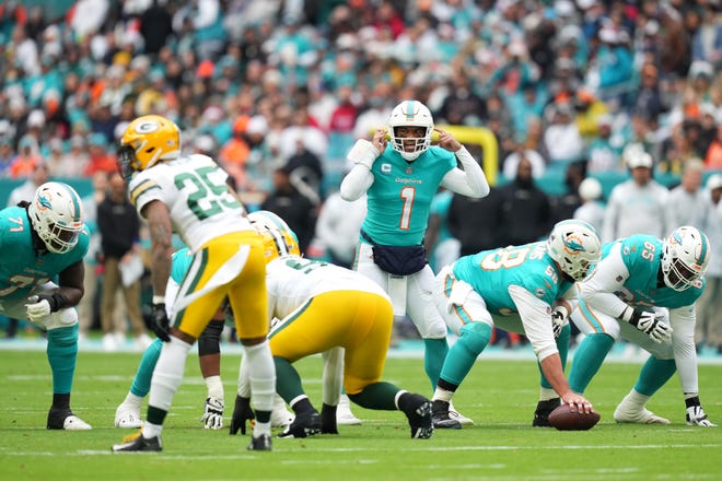 Dec 25, 2022; Miami Gardens, Florida, USA; Miami Dolphins quarterback Tua Tagovailoa (1) signals at the line of scrimmage during the first half against the Green Bay Packers at Hard Rock Stadium. Mandatory Credit: Jasen Vinlove-USA TODAY Sports