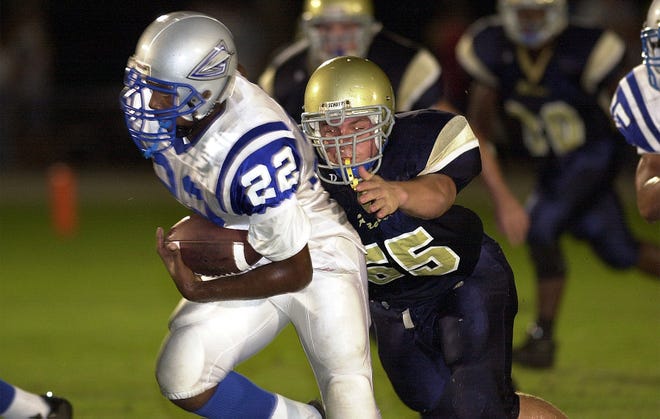 Jon Carroll High School's Stephen Purkey (55), right, goes after Jonnie Daniels of Gulliver Prep in the first quarter of play at John Carroll High School in 2003.