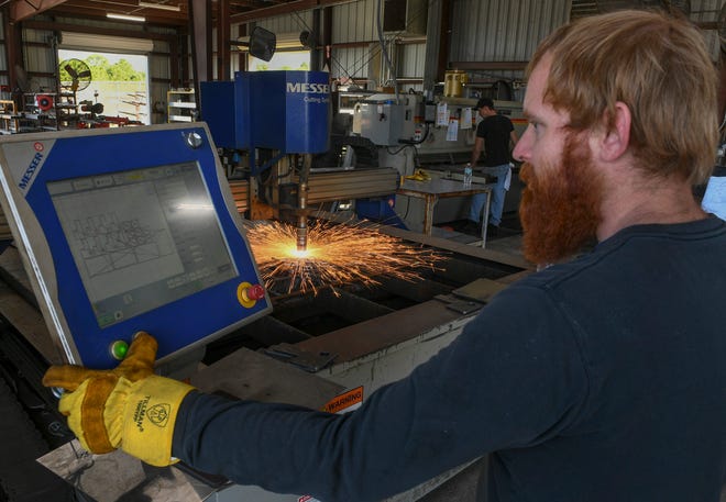 Troy Bradind, a plasma cutter operator at Phoenix Metal Products, monitors the process of making metal components for equipment they produce for the airline industry at their manufacturing facility on Wednesday, Feb. 16, 2022, at the Treasure Coast International Airport and Business Park in Fort Pierce. Phoenix Metal Products is having difficulty acquiring new trucks needed to manufacture some of their airline ground support equipment due to the microchip shortages affecting the automotive industry.