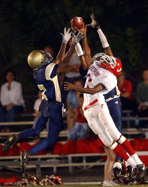 John Carroll's Paul Gibson, left, and Antonio Brunson break up a pass to Frostproof's Jimmy Forbes, center,  in the first quarter of play in 2003.