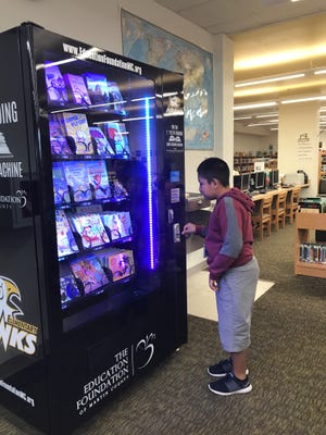 Crystal Lake Elementary student Francisco Otzoy Pec selects a book from the vending machine in the school's media center.