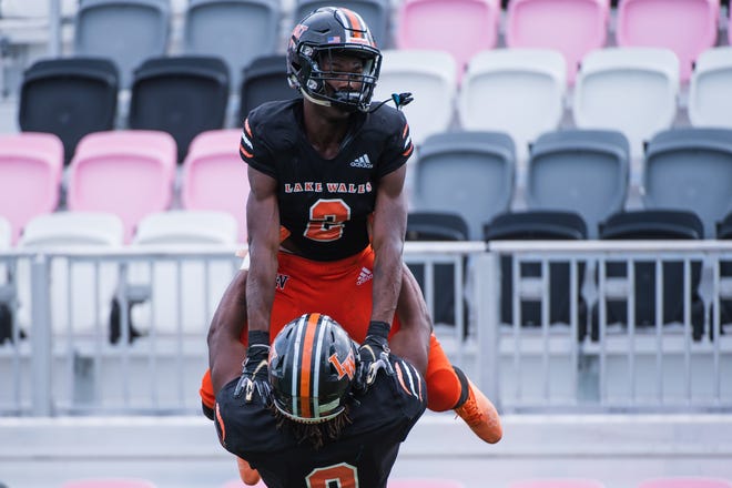 Lake Wales defensive end Terrell James (9) lifts Lake Wales wide receiver Carlos Mitchell (2) in celebration of Mitchell's second quarter touchdown during the Class 3S football state championship game between Lake Wales and Mainland at DRV PNK Stadium on Friday, December 16, 2022, in Fort Lauderdale, FL.