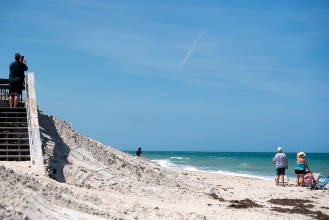 A SpaceX Falcon 9 rocket with 60 satellites ascends to space as beachgoers watch from Wabasso Beach Park on Tuesday, May 4, 2021, in Indian River County.