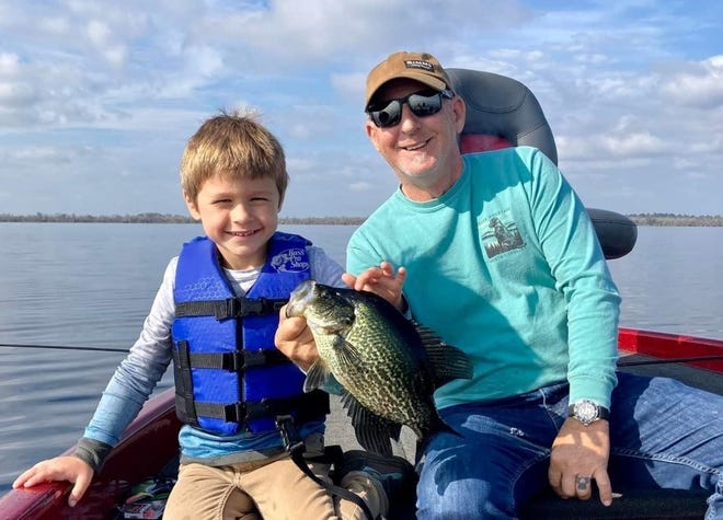 Canaan Mialki, age 4, happily shows off a speckled perch he caught while fishing with grandpa, Dennis Mialki, out of Highland Park in DeLand.