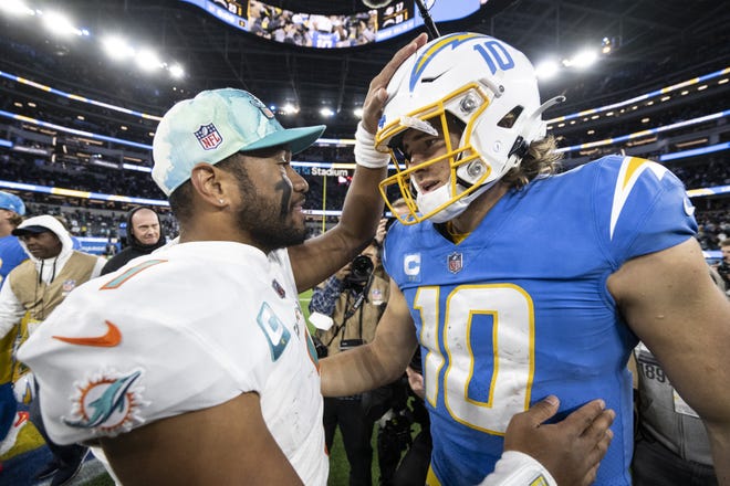 Miami Dolphins quarterback Tua Tagovailoa (1) and Los Angeles Chargers quarterback Justin Herbert (10) hug after an NFL football game, Sunday, Dec. 11, 2022, in Inglewood, Calif. (AP Photo/Kyusung Gong)