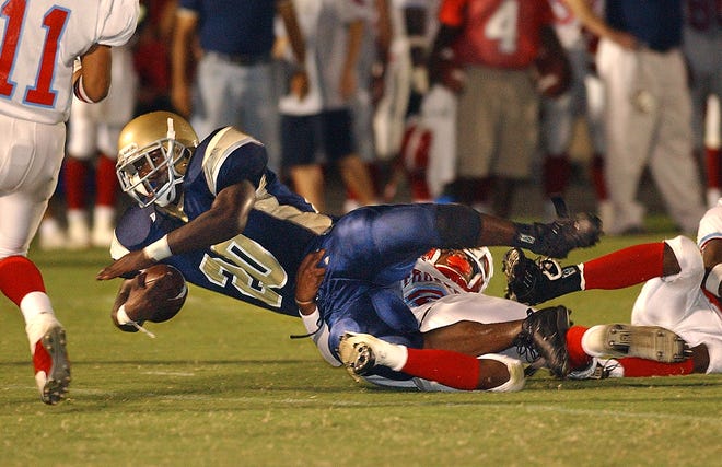 John Carroll's Lester Graham (20) gets caught up in Frostproof defenders early in the first quarter of play at John Carroll High School in 2003.