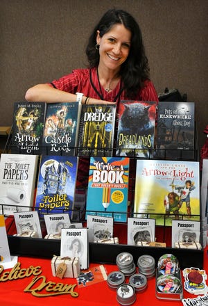 Jaimie Engle, a screenwriter, novelist and producer from Satellite Beach, displays some of her books at the 2022 Melbourne Toy and Comic Con at the Melbourne Auditorium in October.