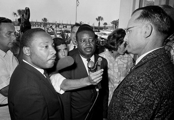 Monson Motor Lodge manager James Brock, right, stops Dr. Martin Luther King, Jr., left, and Rev. Ralph Abernathy at the door of his motel restaurant when they tried to enter with a group to have lunch, June 12, 1964.  The integrationists were arrested when they refused to leave the premises.