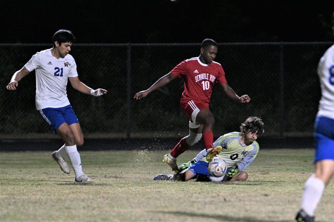 Seminole Ridge's Paul Benoit works the ball past the Martin County keeper before slotting it past the defense to extend the Hawks' lead during the district quarterfinal on Jan. 25, 2023.