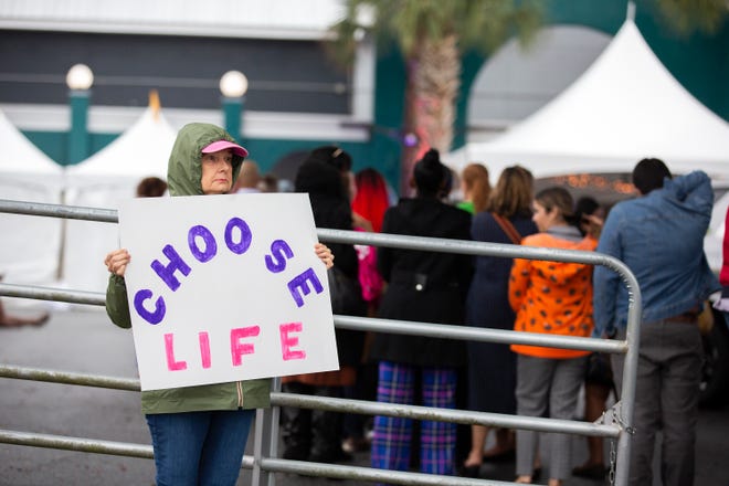 Lone protester Helena Sims stands outside The Moon in Tallahassee, Fla., where Vice President Kamala Harris will speak on the 50th anniversary of Roe v. Wade on Sunday, Jan. 22, 2023.