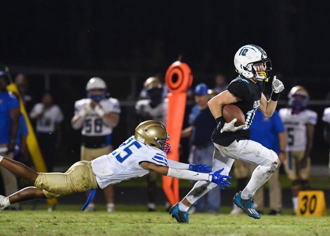 Jensen Beach's Nick Venezia gains yardage as Mainland's Drayden Wood (25) defends in a Region 3-3S high school football final, Friday, Nov. 25, 2022, at Jensen Beach High School. Mainland won 45-10.