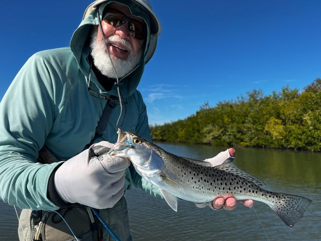 Local fly-fisherman Geno Giza shows off one of many speckled seatrout he brought to the boat this past week in the Edgewater area.