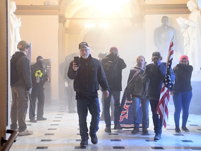Pro-Trump rioters enter the U.S. Capitol as tear gas fills the corridor on Jan. 6, 2021, in Washington, DC.  Mobs breeched security and entered the Capitol as Congress debated the a 2020 presidential election Electoral Vote Certification.