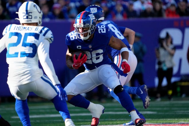 Jan 1, 2023; East Rutherford, NJ; New York Giants running back Saquon Barkley (26)	is shown with the ball before maneuvering past Indianapolis Colts safety Rodney Thomas II (25), at MetLife Stadium. Sunday, January 1, 2023 Mandatory Credit: Kevin R. Wexler-The Record