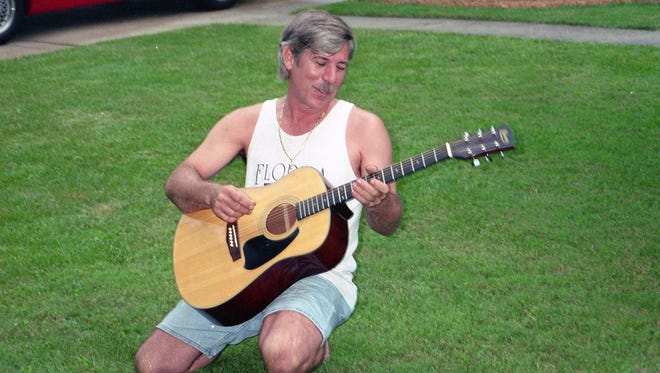 Reginald Chapman Sr. plays guitar outside. Detectives say Chapman Sr. was attacked by his son Dec. 9.