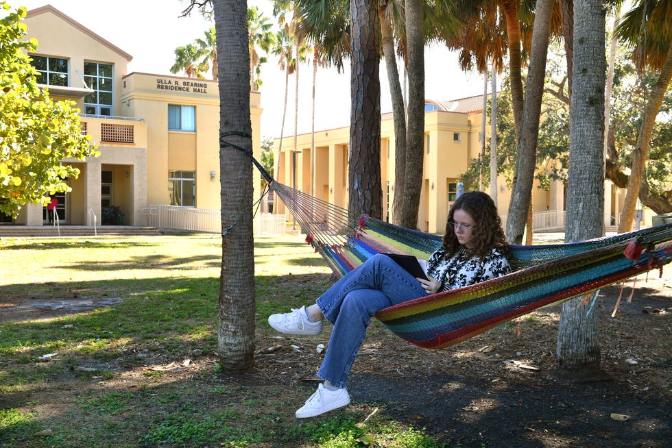 Margo Nielsen, 19, a first-year student studying biology and art, finds a shady spot to read on the New College of Florida campus in Sarasota, Florida on Monday, Jan. 9, 2023. Florida Gov. Ron DeSantis overhauled the board of Sarasota's New College on Friday, bringing in six new members in a move his administration described as an effort to shift the school in a conservative direction.