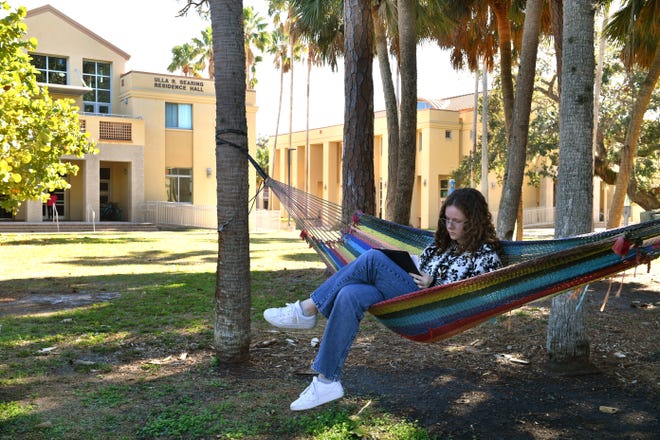 Margo Nielsen, 19, a first-year student studying biology and art, finds a shady spot to read on the New College of Florida campus in Sarasota, Florida on Monday, Jan. 9, 2023. Florida Gov. Ron DeSantis overhauled the board of Sarasota's New College on Friday, bringing in six new members in a move his administration described as an effort to shift the school in a conservative direction.