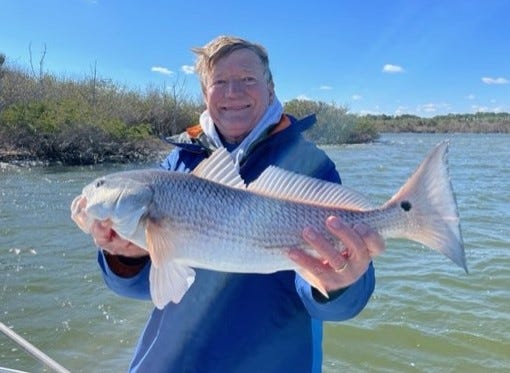 Mel Stack with a 6-pound redfish he caught (and released) while fishing with Capt. Joe Catigano in the Mosquito Lagoon recently.