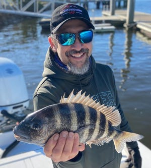 Justin Hoekstra shows off a sheepshead he caught aboard Capt. Jeff Patterson's Pole Dancer charter boat.