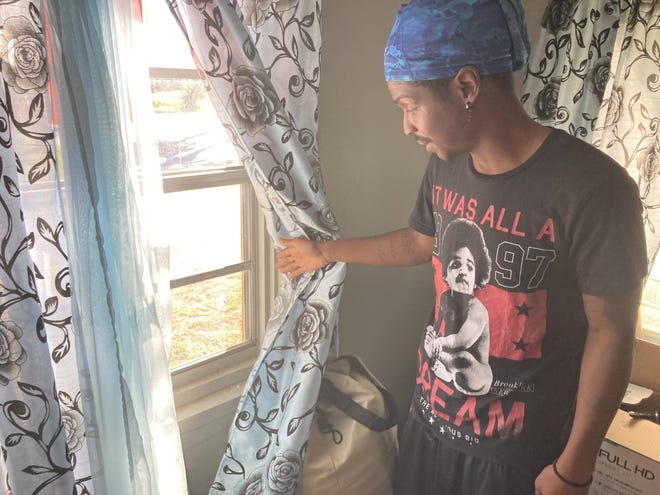 Carrell Gallon on Nov. 29, 2022, pulled back a curtain to show where he said a bullet left a hole in the window. Gallon's grandmother, Mattie Jones, was fatally shot while sitting in the home on Nov. 24, 2022 -- Thanksgiving Day.