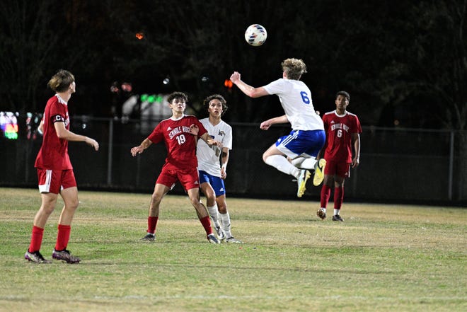 Martin County's Brendan MacKenzie rises to head a pass toward his teammates in the midfield during the Tigers' district quarterfinal match against Seminole Ridge on Jan. 25, 2023.