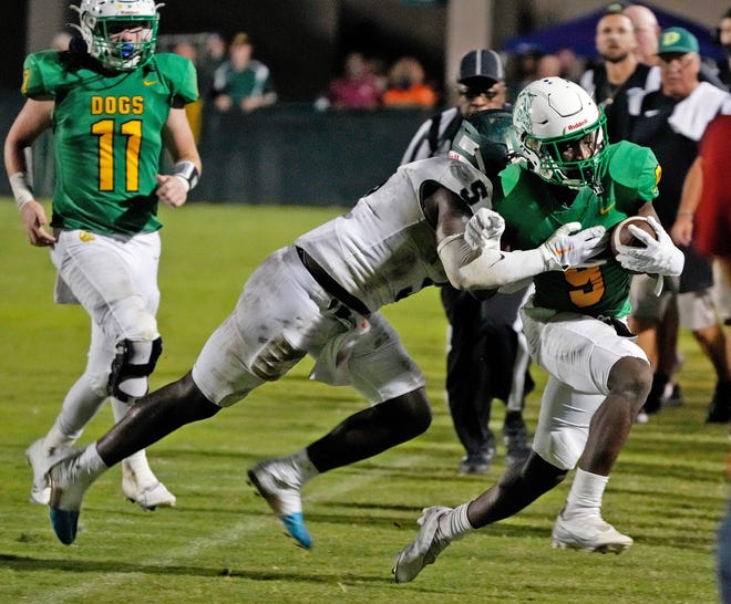 DeLand's Javon Ross (9) gets pushed out of bounds by Flagler Palm Coast's Rodney Hill (5) during a game at Spec Martin Stadium in DeLand, Friday, Nov. 4, 2022.