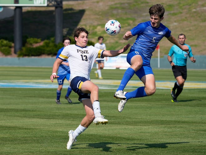 The Pine School Henry Alexandrescu (13) competes with The Canterbury School Dusty Dwyer (5) during the Class 2A Boys Soccer Championship soccer match at Spec Martin Stadium in DeLand, Thursday, Feb. 23, 2023 The Pine School won the championship 2-1.