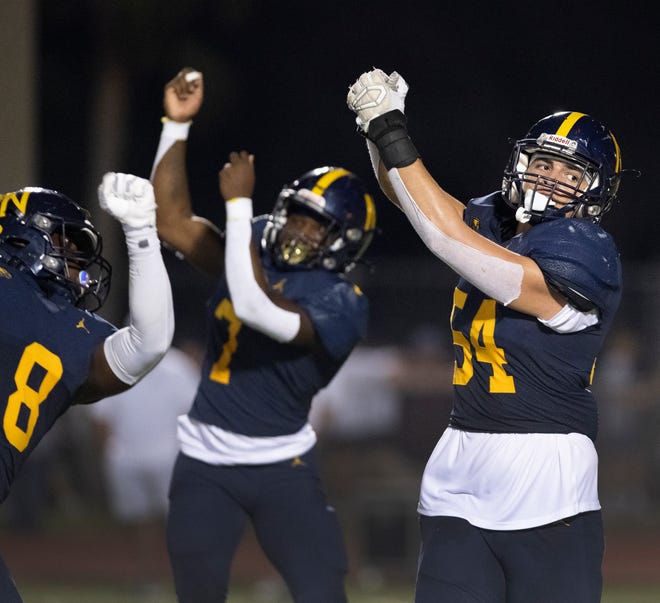 Luke Walker of Naples (54) celebrates with teammates after sacking Barron Collier quarterback Thomas Mooncotch during the game at Naples High on Friday night, October 7, 2022.