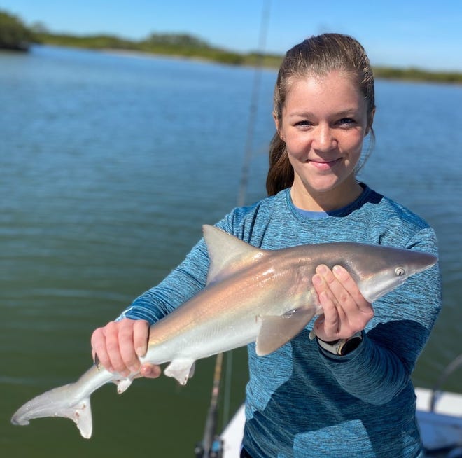 Maddie Schense with a small sandbar shark she caught on Capt. Jeff Patterson's Pole Dancer charter boat.
