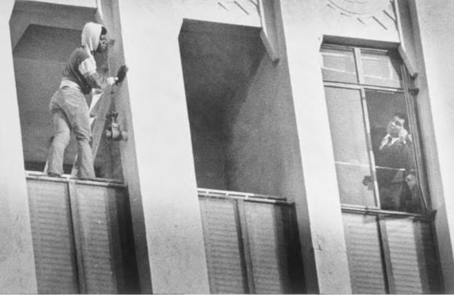 Former Heavyweight champion Muhammad Ali (right) leans out of the window on the ninth floor of a high-rise structure Jan. 19, 1981, and talks with an unidentified man (left) who threatens to jump.