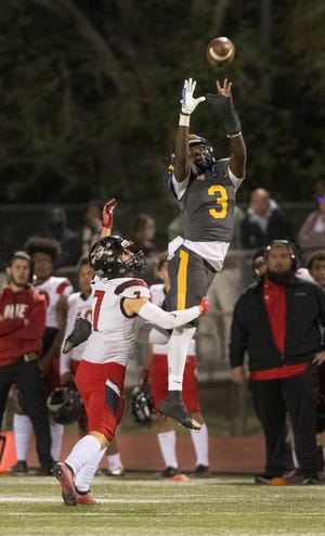 Kensley Faustin of Naples goes up to intercept a pass intended for Justice Becerill of Port Charlotte during the regional semifinal game at Naples High Friday night, November 18, 2022, in Naples.