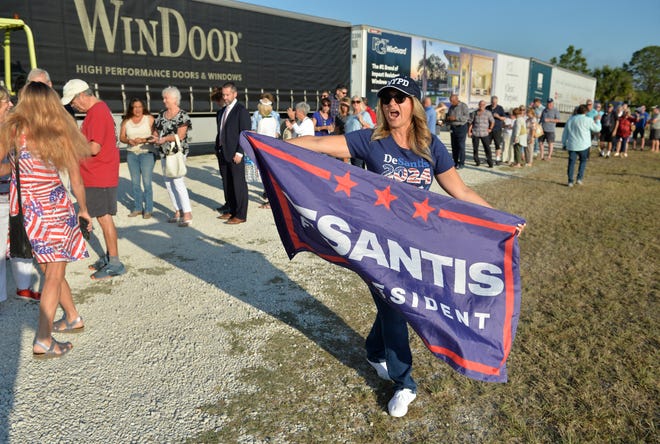 Cathleen Perez, a supporter of Florida Gov. Ron DeSantis gets fellow supporters excited while they wait in line for a campaign-style event where DeSantis introduced his new book "The Courage to be Free" on Tuesday morning at PGT Innovations in Venice.