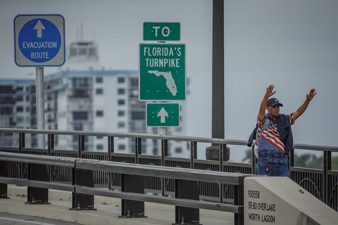 Binyam Haile, of Miami, prays toward Mar-a-Lago as supporters of former President Donald Trump congregate just west of the residence on Southern Boulevard in Palm Beach, on Sunday, March 19.