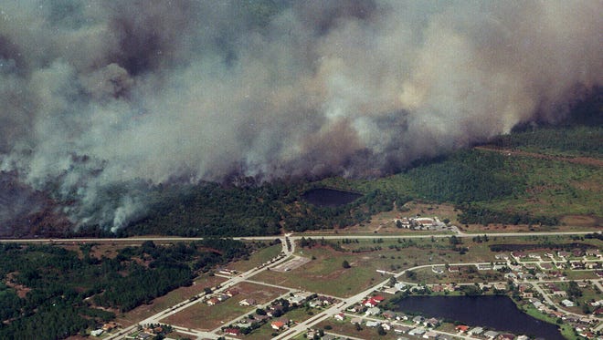 Wildfires burn out of control July 2, 1998, in Brevard and Volusia counties. Smoke from a fire drifted over a subdivision near State Road 520 in central Brevard County. Gov. Lawton Chiles said the wildfires as of July 2, 1998, had damaged or destroyed at least 86 homes in the state of Florida.