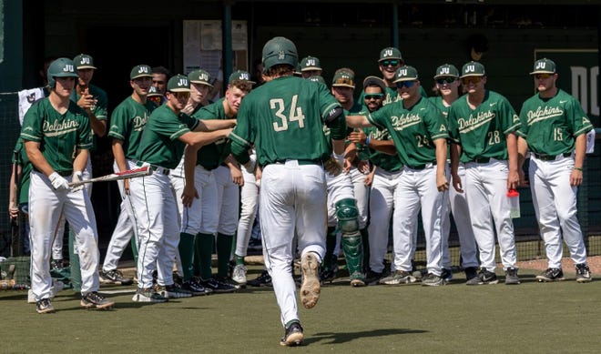 Jacksonville University third baseman Kris Armstrong (34) is greeted by his teammates after a home run against Bradley on March 12.