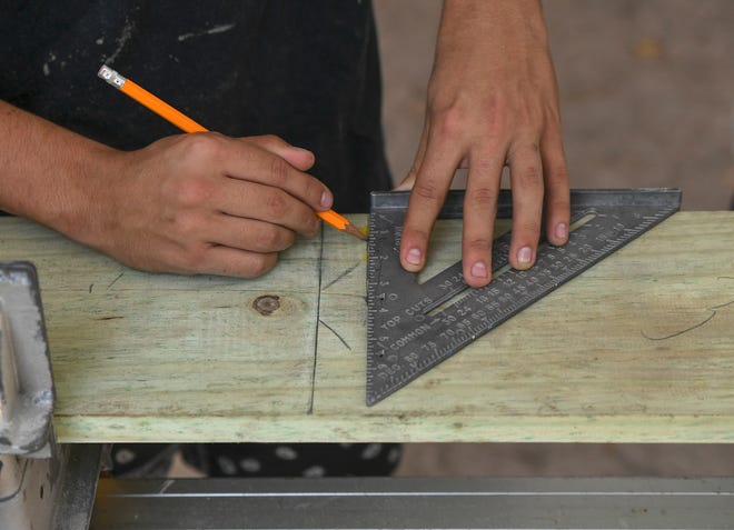 Using a measuring triangle Keenan Ludwig, 17, of Port St. Lucie, marks the area to be cut after measuring twice while learning carpentry skills in the Project Lift program in Fort Pierce.