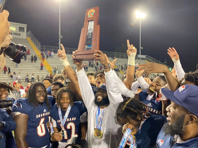 Chaminade-Madonna coach Dameon Jones lifts the Class 1M state championship trophy on Thursday at Gene Cox Stadium in Tallahassee. Chaminade beat Clearwater Central Catholic 48-14.