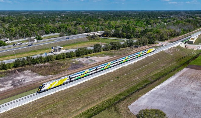 A Brightline test train approaches Dallas Boulevard along the company's tracks just south of the Beachline Expressway.