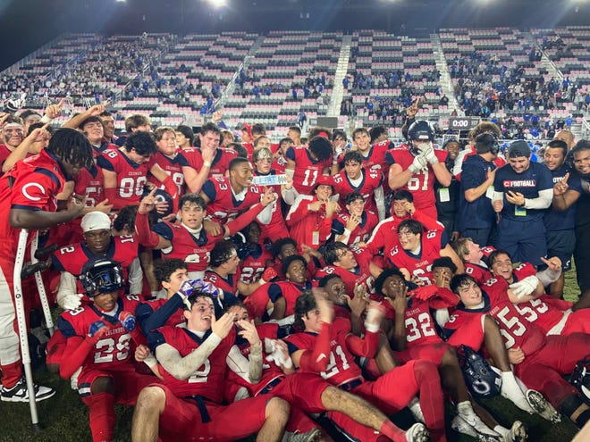 Columbus players celebrate after the winning the Class 4M state championship, 16-13 in overtime against Apopka, on Saturday at DRV PNK Stadium in Fort Lauderdale.