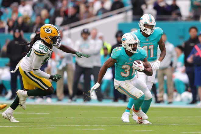 Raheem Mostert of the Miami Dolphins carries the ball during the first quarter of the game against the Green Bay Packers at Hard Rock Stadium on Dec. 25, 2022, in Miami Gardens, Florida.
