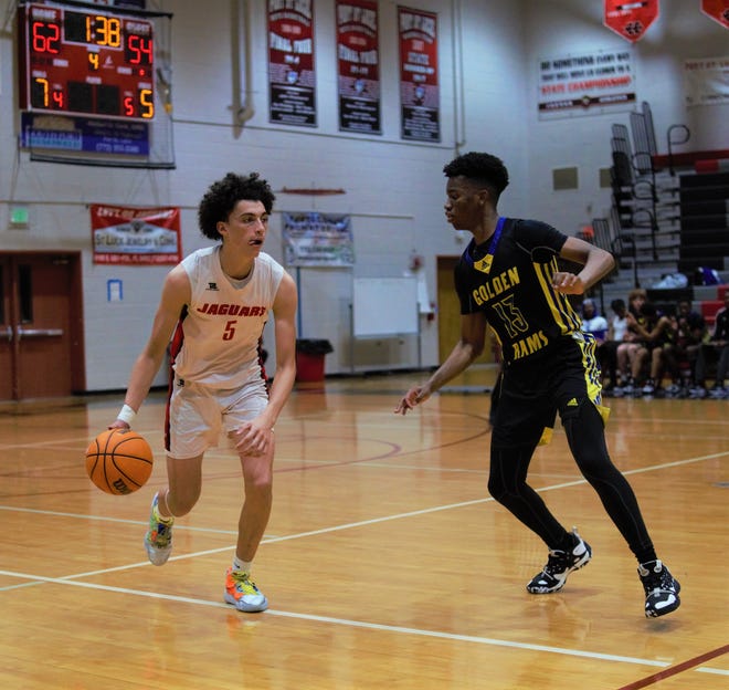 Port St. Lucie's Ryan Rodriguez is guarded by John Carroll Catholic's Collin Jefferson during a high school basketball game on Tuesday, Jan. 3, 2023 in Port St. Lucie. The Rams prevailed 76-73 in overtime.