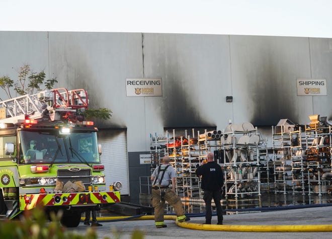Stuart Fire Department members work the scene Saturday at Hog Technologies at Southeast Commerce Avenue and Southeast Market Place, after at least two explosions igniting a large fire were reported at the facility late Friday night in Stuart.