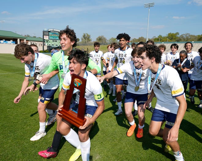 The Pine School players celebrate after winning the Class 2A Boys Soccer Championship match with The Canterbury School 2-1 at Spec Martin Stadium in DeLand, Thursday, Feb. 23, 2023.