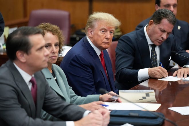 Former President Donald Trump sits at the defense table with his defense team in a Manhattan court, Tuesday, April 4, 2023, in New York. Trump is set to appear in a New York City courtroom on charges related to falsifying business records in a hush money investigation, the first president ever to be charged with a crime.