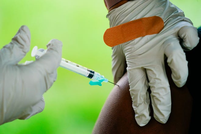 A health worker administers a dose of COVID-19 vaccine during a vaccination clinic in Reading, Pa.